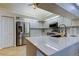 Well lit kitchen includes stainless appliances, white cabinets, breakfast bar, and decorative backsplash at 4967 162Nd N Ave, Clearwater, FL 33760
