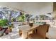 Screened patio with dining table, plants, and comfortable lounge area overlooking the pool at 4967 162Nd N Ave, Clearwater, FL 33760