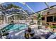 Screened-in pool area with lounge chairs, dining space, and plenty of greenery at 4967 162Nd N Ave, Clearwater, FL 33760