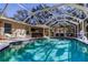 Screened pool with lounge chairs and covered entertaining area at 4967 162Nd N Ave, Clearwater, FL 33760