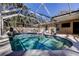 Outdoor pool area with screened enclosure, lounge chairs, and privacy fencing at 4967 162Nd N Ave, Clearwater, FL 33760