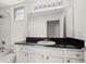 Bathroom features a vanity with black granite countertop, white cabinets, large mirror, and tub with shower at 501 Knights Run Ave # 2101, Tampa, FL 33602