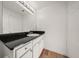 Bathroom with vanity, black countertop, white cabinets and big mirror at 501 Knights Run Ave # 2101, Tampa, FL 33602