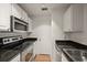Kitchen boasts stainless steel appliances, white cabinets, granite countertops, and tile backsplash at 501 Knights Run Ave # 2101, Tampa, FL 33602