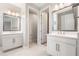 Bathroom showcasing dual vanities, each with mirrors and sinks, separated by an open doorway at 5087 San Martino Dr, Wesley Chapel, FL 33543