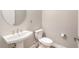 Bathroom featuring a pedestal sink, round mirror, and white toilet at 5087 San Martino Dr, Wesley Chapel, FL 33543