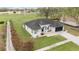 Overhead perspective of a modern one-story home with a lush green lawn and long driveway at 6140 Silver Oaks Dr, Zephyrhills, FL 33542