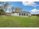 View of the home's backyard featuring a patio with outdoor furniture and a well-maintained lawn at 6140 Silver Oaks Dr, Zephyrhills, FL 33542