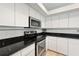 Kitchen featuring white cabinets, stainless steel appliances, and granite countertops at 6140 Silver Oaks Dr, Zephyrhills, FL 33542