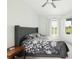 Comfortable main bedroom featuring a queen bed with floral bedding and bright windows at 6140 Silver Oaks Dr, Zephyrhills, FL 33542