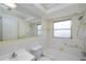 Well-lit bathroom with tiled walls, a large mirror, and a shower-tub combination at 7847 39Th N Ter, St Petersburg, FL 33709