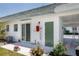 Exterior view of home featuring an AC unit, white walls, and green doors at 7847 39Th N Ter, St Petersburg, FL 33709