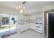 Well-lit kitchen featuring white cabinetry and a sliding door to the outside at 7847 39Th N Ter, St Petersburg, FL 33709