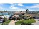Aerial view of a large waterfront home with a well-manicured lawn and mature trees at 7986 9Th S Ave, St Petersburg, FL 33707