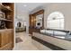 Bathroom featuring a built-in tub, dark countertops, and wood cabinets, connecting seamlessly to the luxurious main bedroom at 7986 9Th S Ave, St Petersburg, FL 33707