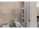 Elegant bathroom featuring stylish tiled walls and a modern toilet with a convenient storage shelf at 7986 9Th S Ave, St Petersburg, FL 33707