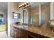 Primary bath featuring granite vanity with double sinks and a large framed mirror at 7986 9Th S Ave, St Petersburg, FL 33707
