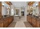 Elegant bathroom featuring dual vanities with dark countertops, a luxurious bathtub, and a spacious walk-in shower at 7986 9Th S Ave, St Petersburg, FL 33707