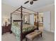 Spacious bedroom featuring a canopy bed with a leafy comforter, complemented by dark wood furniture and an ensuite bathroom at 7986 9Th S Ave, St Petersburg, FL 33707