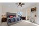Bedroom with tufted headboard bed, bathroom access, and natural lighting at 7986 9Th S Ave, St Petersburg, FL 33707