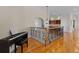 Open hallway with a piano and wrought iron banister looking into the recreation area at 7986 9Th S Ave, St Petersburg, FL 33707