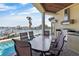 Outdoor kitchen next to the pool featuring a grill, stainless steel hood, and a dining table with waterfront views at 7986 9Th S Ave, St Petersburg, FL 33707