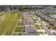 Aerial view showcases the layout of a residential area with lush greenery, pond, and well-maintained roads at 8034 Broad Pointe Dr, Zephyrhills, FL 33540