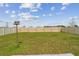 Expansive backyard with lush green grass, a charming birdhouse, and a well-maintained privacy fence at 8034 Broad Pointe Dr, Zephyrhills, FL 33540