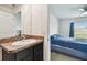 Bathroom vanity that leads to bedroom with natural light and carpet at 8034 Broad Pointe Dr, Zephyrhills, FL 33540