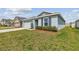 Well-maintained single-story home featuring green grass, a trimmed bush, and an attached two-car garage at 8034 Broad Pointe Dr, Zephyrhills, FL 33540