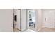 Bright hallway with tile floors connecting a bathroom, bedroom, and the front door at 8034 Broad Pointe Dr, Zephyrhills, FL 33540