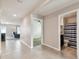 Well-lit hallway with tile flooring leading to a bathroom, living room, and bedroom at 8034 Broad Pointe Dr, Zephyrhills, FL 33540