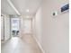 Clean hallway with tile flooring, connecting various rooms and showcasing modern thermostat at 8034 Broad Pointe Dr, Zephyrhills, FL 33540