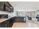 Modern kitchen with black appliances, granite countertops, and open view to the living area at 8034 Broad Pointe Dr, Zephyrhills, FL 33540