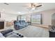 Open-concept living room with stylish furniture, natural light, and a ceiling fan at 8034 Broad Pointe Dr, Zephyrhills, FL 33540