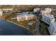 Aerial view of condo community, pool, lush landscaping, and waterfront views at 100 Oakmont Ln # 112, Belleair, FL 33756