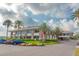 Exterior of a two-story building with lush landscaping, a circular driveway, and palm trees at 100 Oakmont Ln # 112, Belleair, FL 33756