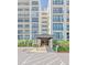 Building exterior featuring private balconies, a covered entry, and manicured greenery at 100 Oakmont Ln # 112, Belleair, FL 33756