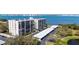 Exterior view of condo building, parking, and water views in a tranquil setting at 100 Oakmont Ln # 112, Belleair, FL 33756