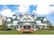 The Belleview Inn is a historic, white building with a green roof, manicured lawn, and an American flag at 100 Oakmont Ln # 112, Belleair, FL 33756