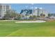 Scenic view of the golf course with lush green grass and luxury buildings in the background, perfect for golfers at 100 Oakmont Ln # 112, Belleair, FL 33756