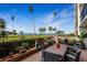 Waterfront patio features a dining table with seating overlooking a manicured lawn and ocean views at 100 Oakmont Ln # 112, Belleair, FL 33756