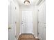 A foyer featuring neutral walls, tan floors, and a white front door flanked by white doors at 10819 Kensington Park Ave, Riverview, FL 33578