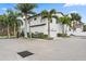 View of modern townhome featuring palm trees, manicured landscaping, and two car garage at 1110 25Th N St, St Petersburg, FL 33713