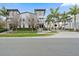 Modern townhome with gray exterior, complemented by tropical palm trees and lush green landscaping in front at 1110 25Th N St, St Petersburg, FL 33713