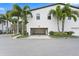 View of the attached two car garage featuring white painted walls, storage, and lush landscaping outside at 1110 25Th N St, St Petersburg, FL 33713