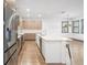 Modern kitchen with stainless steel appliances, white countertops, wood floors, and a spacious island with sink at 1110 25Th N St, St Petersburg, FL 33713
