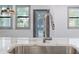 Close-up of a modern stainless steel sink with chrome faucet and white marble countertop, featuring a window view at 1110 25Th N St, St Petersburg, FL 33713
