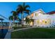 This luxury waterfront home boasts an expansive lawn, a private dock, mature palms, and an extended rounded balcony at 119 Carlyle Cir, Palm Harbor, FL 34683