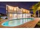 Night view of backyard pool, featuring brick pool deck and a manicured lawn at 119 Carlyle Cir, Palm Harbor, FL 34683